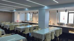 ein Speisesaal mit Tischen und Stühlen in einem Restaurant in der Unterkunft GreenTree Inn Hefei East Wangjiang Road CTCE Express Hotel in Hefei