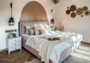 a bedroom with a large white bed with an arch above it at LohonoStays Villa Beleza C in Oxel +14 photos