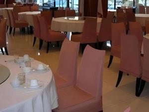 a dining room with tables and chairs with white tablecloths at Jinjiang Inn Select Yangzhou Shouxi Lake Siwangting Road in Yangzhou