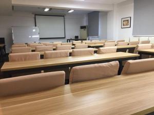 an empty classroom with tables and chairs and a whiteboard at Jinjiang Inn Select Yangzhou Shouxi Lake Siwangting Road in Yangzhou