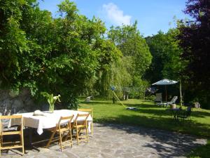 - une table avec des chaises et un parasol dans la cour dans l'établissement Mote Cottage, à Mutriku