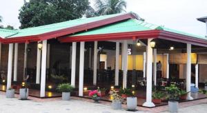 ein Restaurant mit Pflanzen vor einem Gebäude in der Unterkunft Sihilro Regency Hotel in Udawalawe