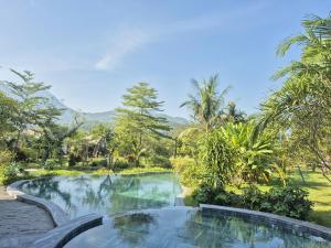 una piscina nel mezzo di un giardino alberato di Bavi Myan Maison a Yên Cư