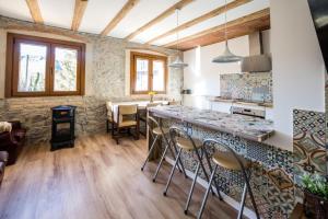 a kitchen with a counter and chairs in a room at Rural apartment La Cantonada in Guardiola de Berguedà