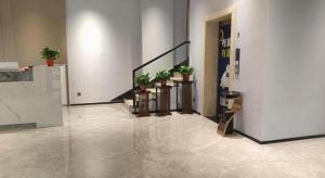a lobby with stairs and potted plants in a building at 7 Days Inn Pingxiang Railway Station in Pingxiang