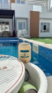 a cup of coffee sitting on the edge of a swimming pool at شاليه ڤيو in Al Ḩadd