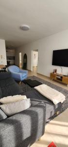 a living room with a couch and a flat screen tv at Modern Family Apartment by IsrApart in H̱olon