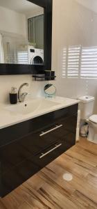 a bathroom with a sink and a mirror at Modern Family Apartment by IsrApart in H̱olon