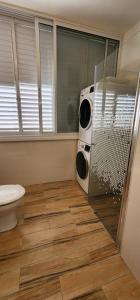 a bathroom with a shower and a toilet in it at Modern Family Apartment by IsrApart in H̱olon +25 photos