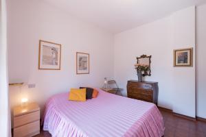ein Schlafzimmer mit einem großen Bett und einer Kommode in der Unterkunft Comfort Beach House in Marina di Massa