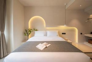 a bedroom with a bed with a book on it at Yijianju Garden Inn in Lijiang +48 photos