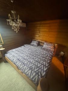 a bedroom with a bed with a wooden wall at Kosmajska Bajka in Rogača