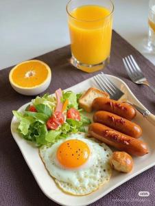 un plato de desayuno con huevos, salchichas y ensalada en Boutique Saigon 16, en Ho Chi Minh