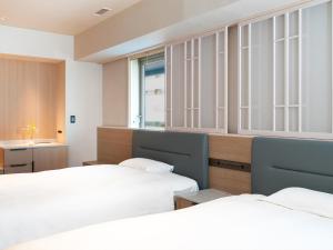 ein Schlafzimmer mit zwei Betten und einem Fenster in der Unterkunft Kobe Marriott Hotel in Kōbe