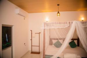 Wilpattu Wild Cottages في Nochchiyagama: غرفة نوم بسرير مع ناموسية