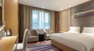 a hotel room with a bed and chairs and a window at Lavande Hotels Suzhou Railway Station in Suzhou +180 photos