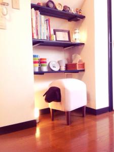 a white chair sitting in a room with shelves at Love Kyoto Kyoenkan in Kyoto