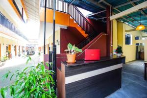 um átrio com uma escada num edifício com plantas em OYO 1720 A2b Residence em Malalayang