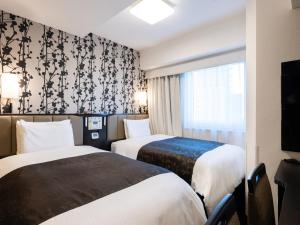 Giường trong phòng chung tại APA Hotel Takaoka Ekimae