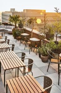 Un patio al aire libre con mesas, sillas y plantas. en Boutique Saigon 16, en Ho Chi Minh