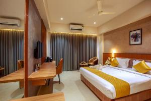 una camera d'albergo con un letto grande e una scrivania di Oban Residency a Karukachal Altre 5 foto