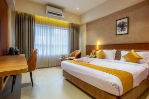 una camera d'albergo con un letto grande e una scrivania di Oban Residency a Karukachal