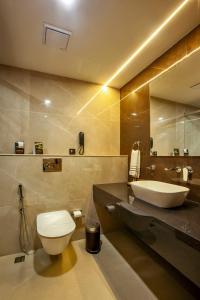 KarukachalにあるOban Residencyの白いトイレと洗面台のあるバスルーム