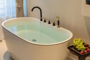 a bath tub with a bunch of fruit in a bathroom at Yijianju Garden Inn in Lijiang