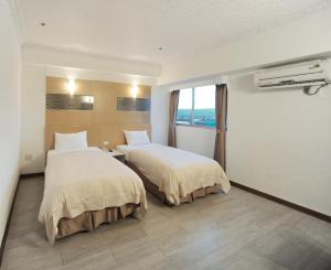 Postel nebo postele na pokoji v ubytování Kenting Holiday Hotel