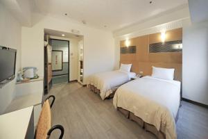 Postel nebo postele na pokoji v ubytování Kenting Holiday Hotel
