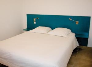 a bedroom with a large white bed with a blue headboard at Résidence Thalacap in Cap d'Agde