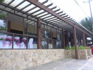 un edificio con finestre in vetro e una parete in pietra di Alfonso Hotel a Upli