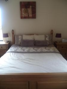 a large bed in a bedroom with two night stands at Sea Breeze in Canower