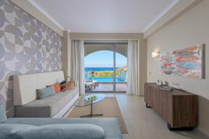 ein Wohnzimmer mit Sofa und Meerblick in der Unterkunft Atrium Platinum Resort & Spa in Ixia