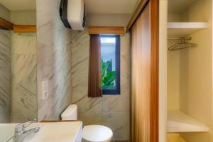 a bathroom with a toilet and a sink and a window at Andewi Cabin in Canggu +14 photos