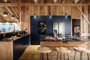 a kitchen with wooden walls and a counter with stools at Chalet Trumont - OVO Network in Morillon