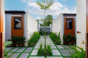 a courtyard of a house with wooden doors and plants at Andewi Cabin in Canggu