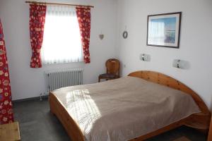 Ferienhaus Nr 124, Kategorie Economy, Feriendorf Hochbergle, Allgäu في Karlsebene: غرفة نوم بسرير خشبي ونافذة