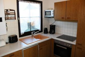 Ferienhaus Nr 124, Kategorie Economy, Feriendorf Hochbergle, Allgäu في Karlsebene: مطبخ مع حوض ونافذة +10 صور