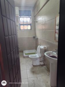 un bagno con un water e un lavandino di Sonkoyaz bed and breakfast a Entebbe