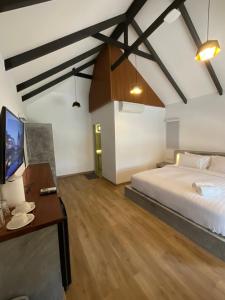 a bedroom with a bed and a desk and a tv at Island Spa Resort in Koh Tao