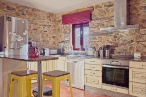 eine Küche mit einem Tisch und gelben Stühlen in der Unterkunft Casa Rural Ucedo in Ucedo + 27 Fotos