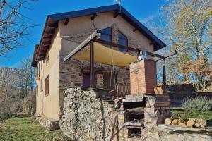 ein Steinhaus mit einer Veranda und einer Steinmauer in der Unterkunft Casa Rural Ucedo in Ucedo