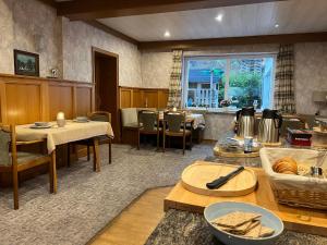 a dining room with tables and chairs and a window at Pension Mountain View Sauerland in Winterberg
