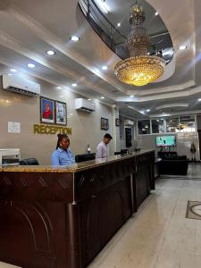 Dos personas de pie en una barra de un restaurante. en Rainbow Hotel, en Dar es Salaam