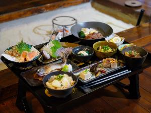 ein Tisch mit vielen verschiedenen Arten von Essen darauf in der Unterkunft 信州の古民家宿 真秀ろばmahoroba in Nagano