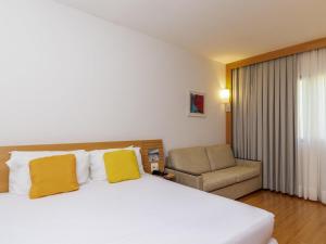 een hotelkamer met een bed en een stoel bij Novotel Campo Grande in Campo Grande +79 foto's