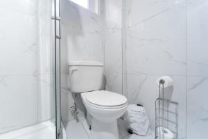 a white bathroom with a toilet and a shower at Cozy Private 2 bedroom apartment, free Wifi, free parking in heart of Toronto, surrounded by nature in Toronto +15 photos