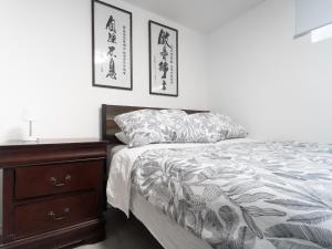 a bedroom with a bed and a wooden dresser at Cozy Private 2 bedroom apartment, free Wifi, free parking in heart of Toronto, surrounded by nature in Toronto