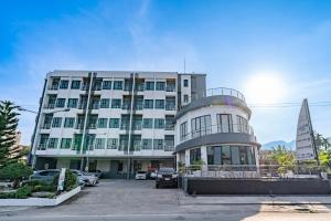 拉廊加拉酒店的一座大型白色建筑，前面停着一艘帆船。